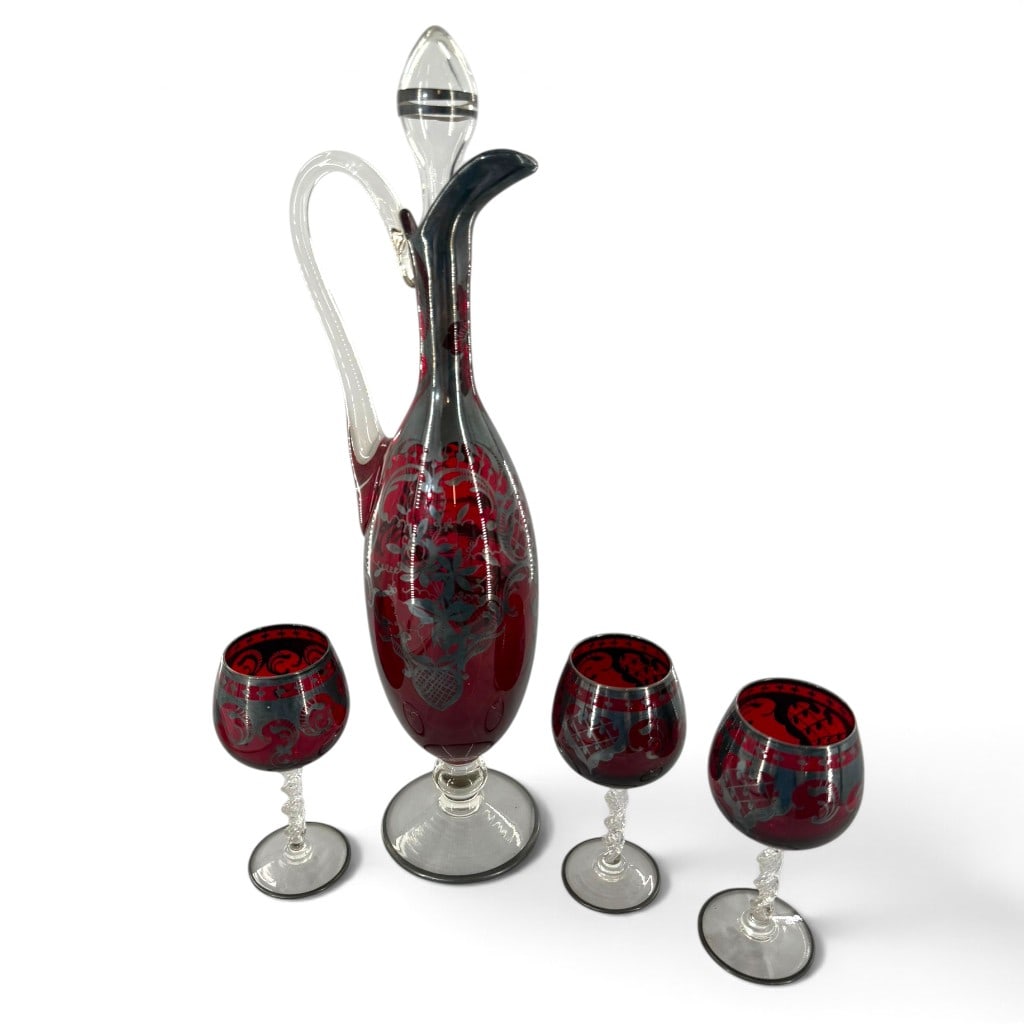 Cranberry Glass Silver-Overlay Decanter Set: Origin: Probably Continental European Date: Mid-20th century Period/Style: Mid-century decorative glass Maker: Unmarked Materials: Cranberry and clear glass with silver-colored applied overlay Form:
