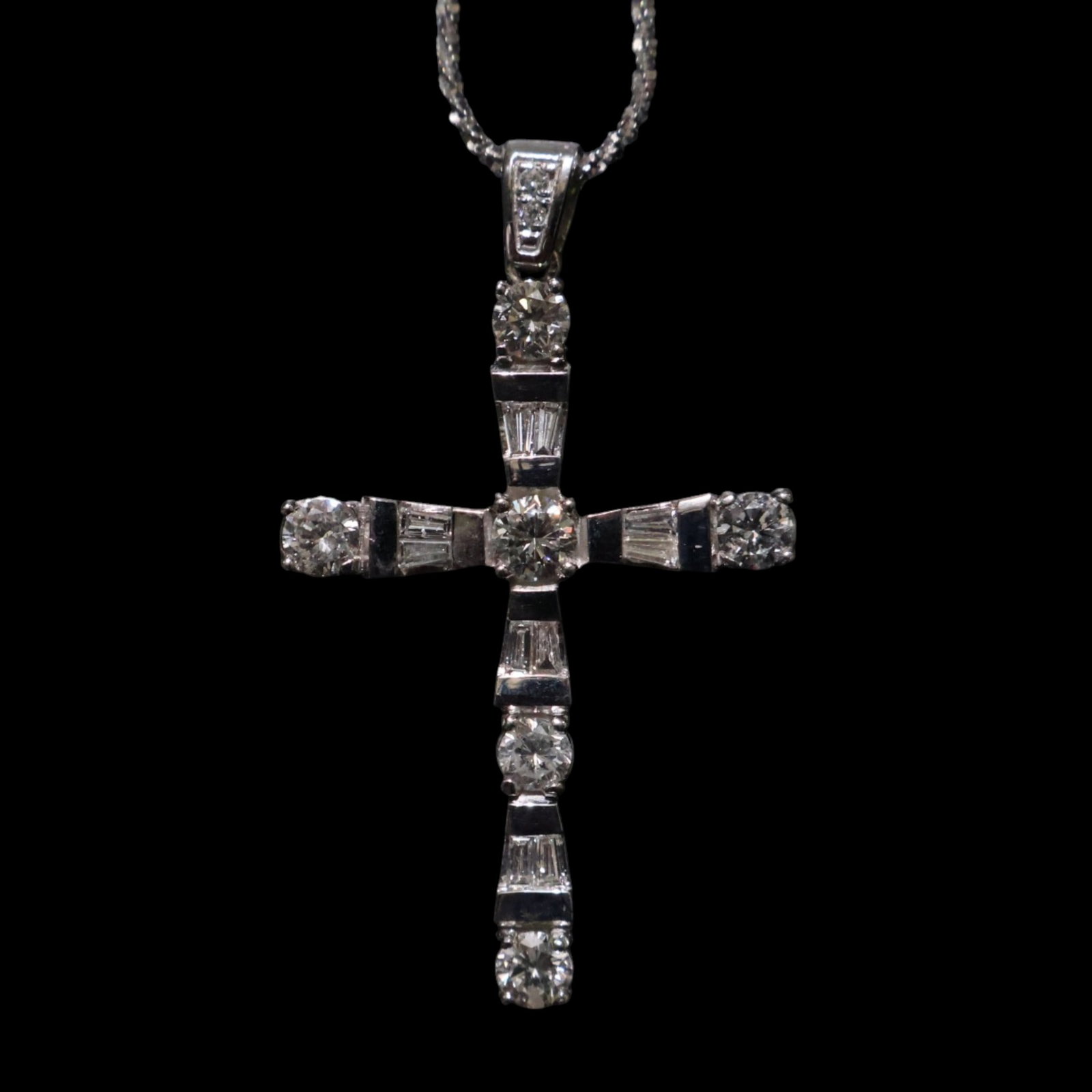 14K White Gold Diamond Cross Necklace: Date: Late 20th to early 21st century Materials: 14K white gold and diamonds Form: Cross pendant necklace Description: A 14K white gold cross pendant set with round and tapered baguette diamonds,