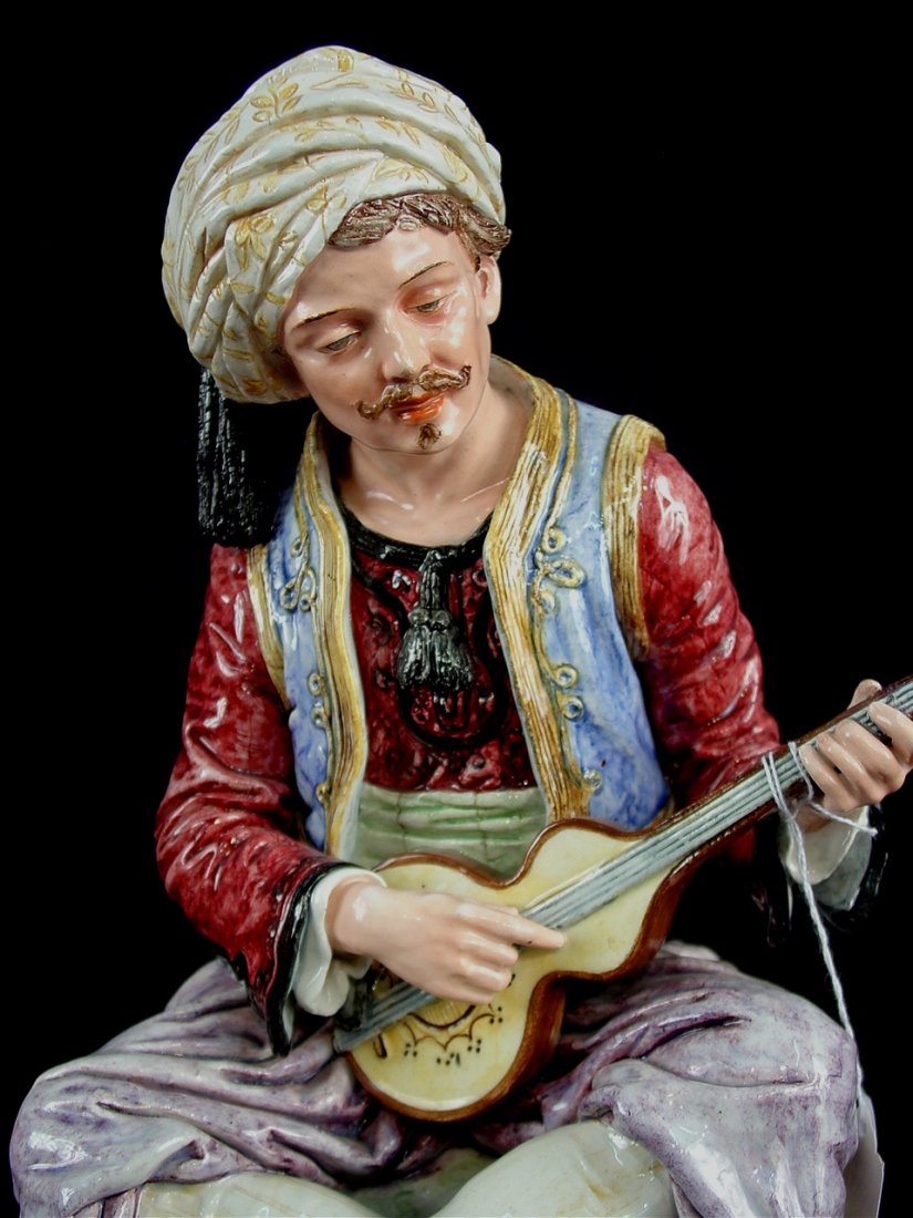 Pair of Majolica figures sitting on attached base,: Pair of Majolica figures sitting on attached base, Arabian dress with musical instrument, 19in. T.