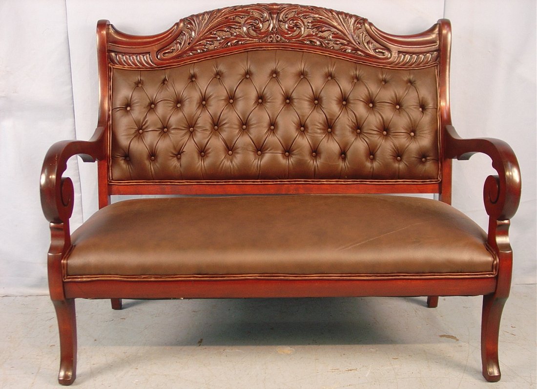 571: Heavily carved solid mahogany love seat with: Heavily carved solid mahogany love seat with empire scroll arms, brown leather, ca. 1880, 48in. W, 43in. T, 24in. D.