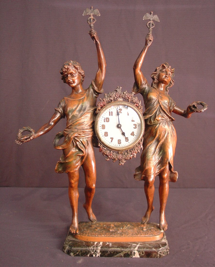 122: Art Nouveau figural clock of man and woman on: Art Nouveau figural clock of man and woman on black marble base, 20IN T, 17IN W, 7IN D
