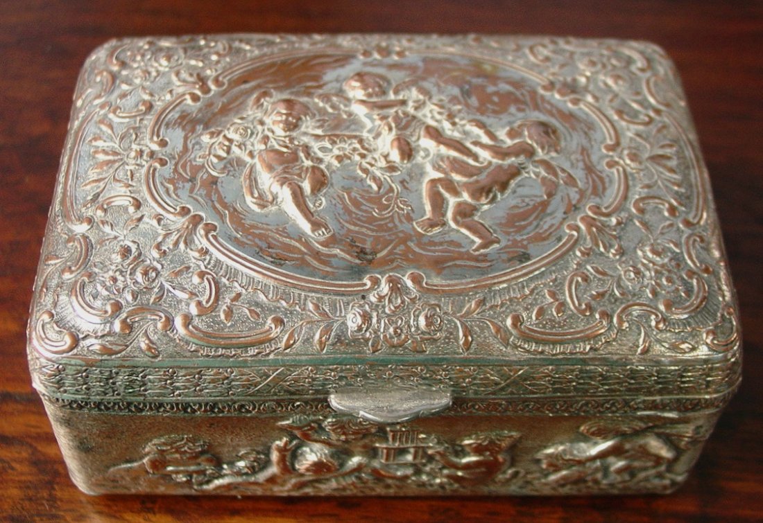 316: Silver over copper box, has cupid and angel: Silver over copper box, has cupid and angel figures on top and sides, very ornate with rounded top, 5.5IN L, 3.5IN W, 2IN D