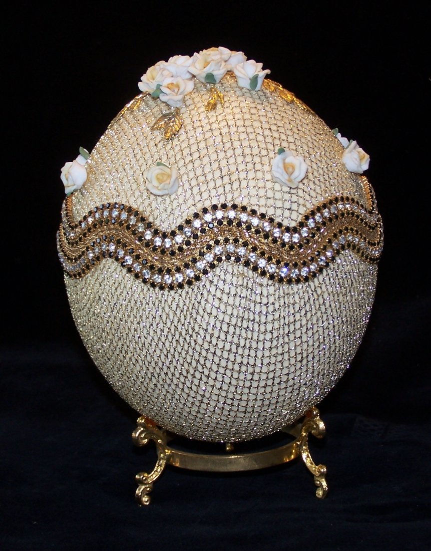 Real Ostrich Egg Jewelry Trinket Box: Beautiful Real Ostrich Egg Jewelry or Trinket Box. The egg is covered with Gold Lace with porcelain flowers on top. Inside the egg is a chocolate brown satin. The egg has a -/gold color base. 7-1/2" t
