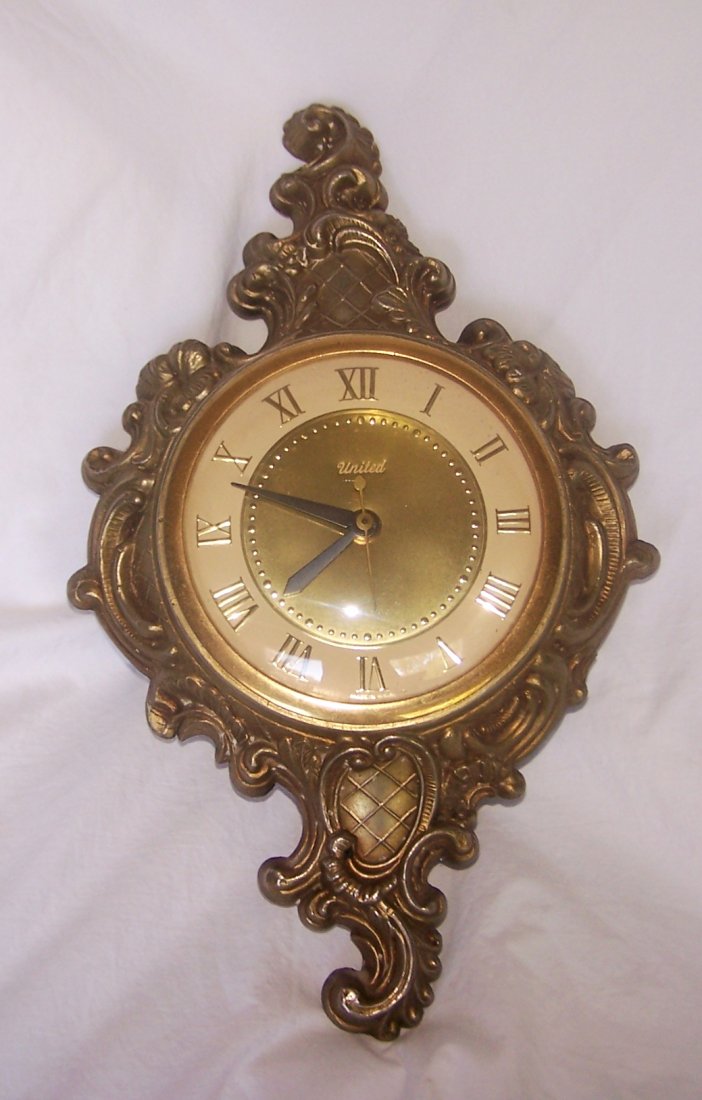 Vintage United Model 84 Electric Sconce Wall Clock: Very Pretty vintage United electric wall clock. The clock is made in a style that looks like a wall sconce. It appears to be made of brass. It is model 84 and is working. 14-1/2" tall x 9" wide x 2" d