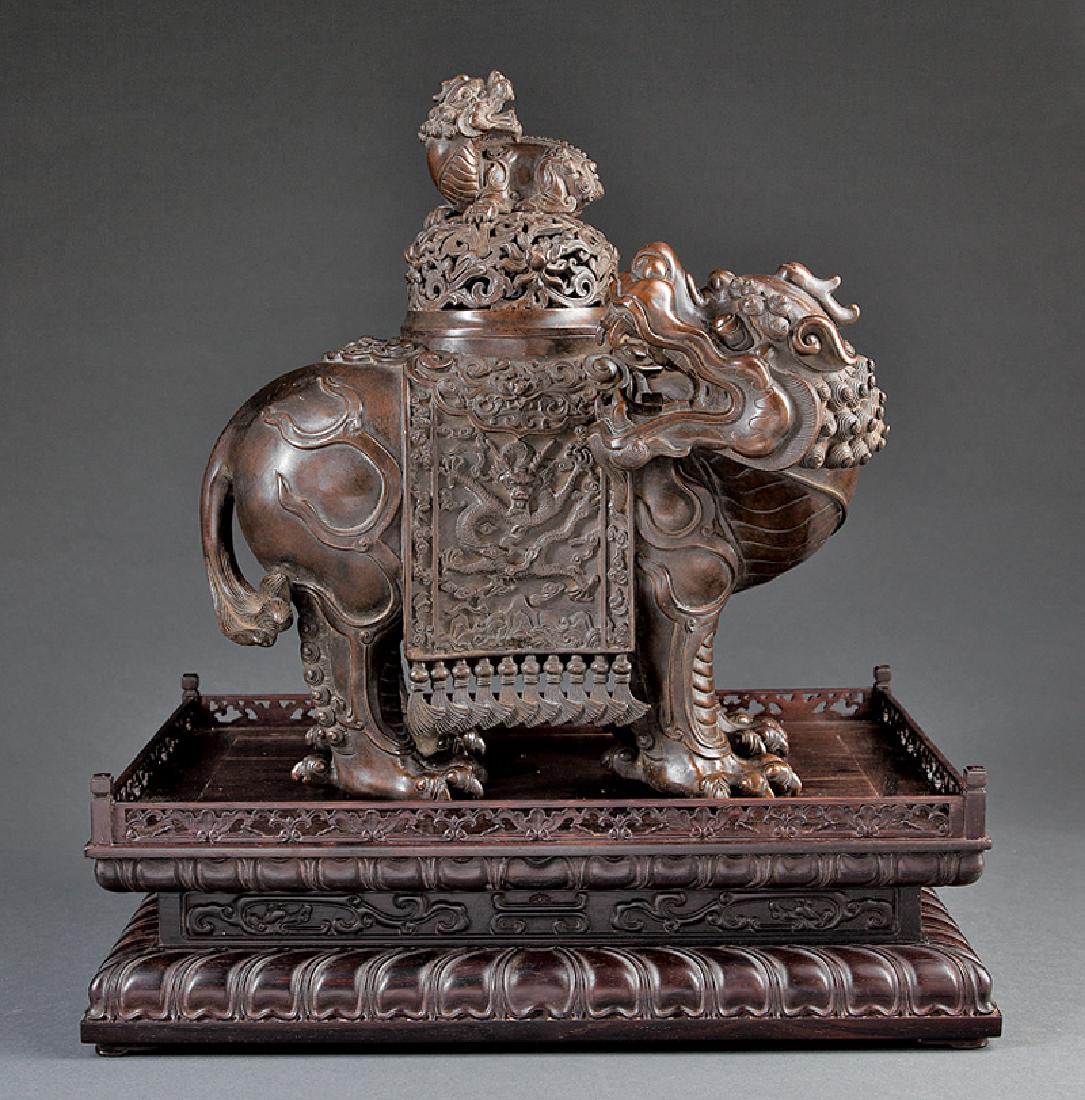 Chinese Patinated Bronze Buddhist Lion Censer: Chinese Patinated Bronze Buddhist Lion Censer, probably 20th c., openwork domed cover surmounted by a Buddhist lion, inscribed, h. 15 1/4 in., w. 14 1/2 in., hardwood stand, probably Huanghuali, overa