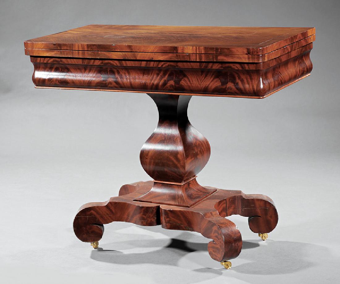 American Classical Mahogany Games Table: American Classical Mahogany Games Table, 19th c., foldover top, ogee frieze, paneled vasiform standard, shaped plinth, scrolled feet, casters, h. 30 1/4 in., w. 35 3/4 in., d. 17 3/4 in
