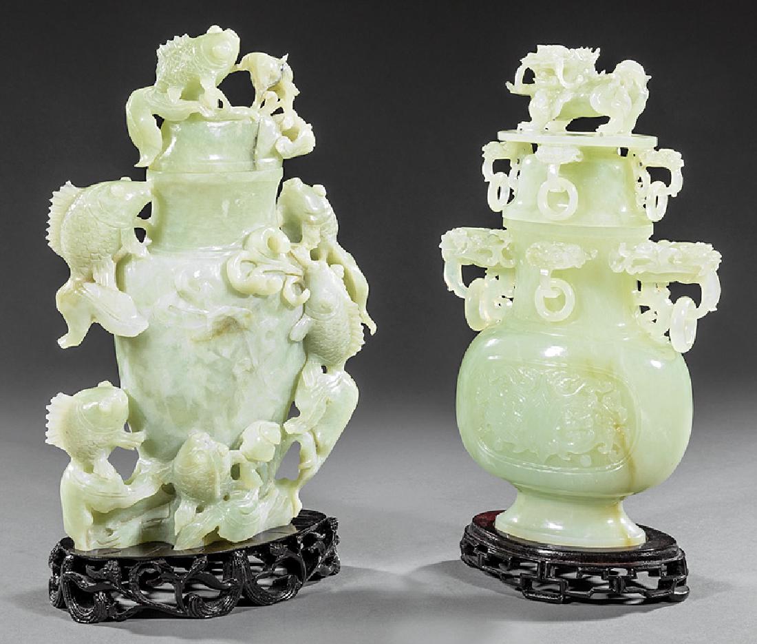 Two Chinese Carved Serpentine Covered Vases: Two Chinese Carved Serpentine Covered Vases, 20th c., first with Buddhist lion finial, lion's mask loose ring handles; second with fish finial and fish and water reed body, h. 11 in. and 11 1/2 in., s