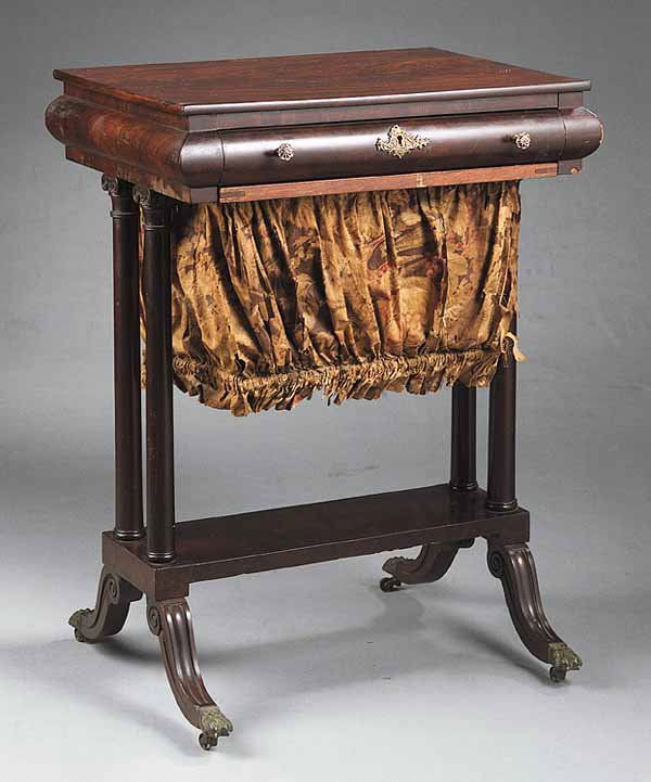 Antique American Classical-Style Mahogany Work: An Antique American Classical-Style Mahogany Work Table , late 19th c., in the manner of Duncan Phyfe, the top above a bollection drawer fitted with a tray and work bag, paired columnar supports conne