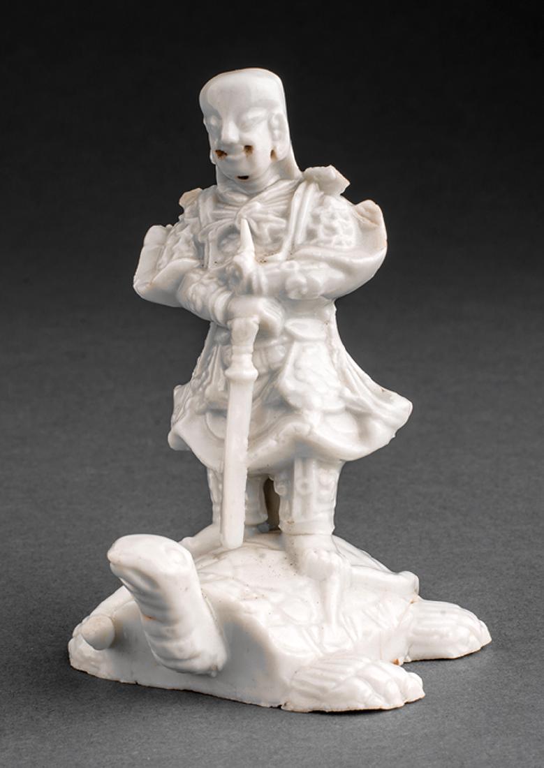Chinese "Blanc-de-Chine" Porcelain Zhenwu: Chinese "Blanc-de-Chine" Porcelain Figure of Zhenwu, Qing Dynasty (1644-1911), modeled standing with a sword on a tortoise, h. 3 in.; together with a white glazed Buddhist lion, first h. 3 3/4 in., se