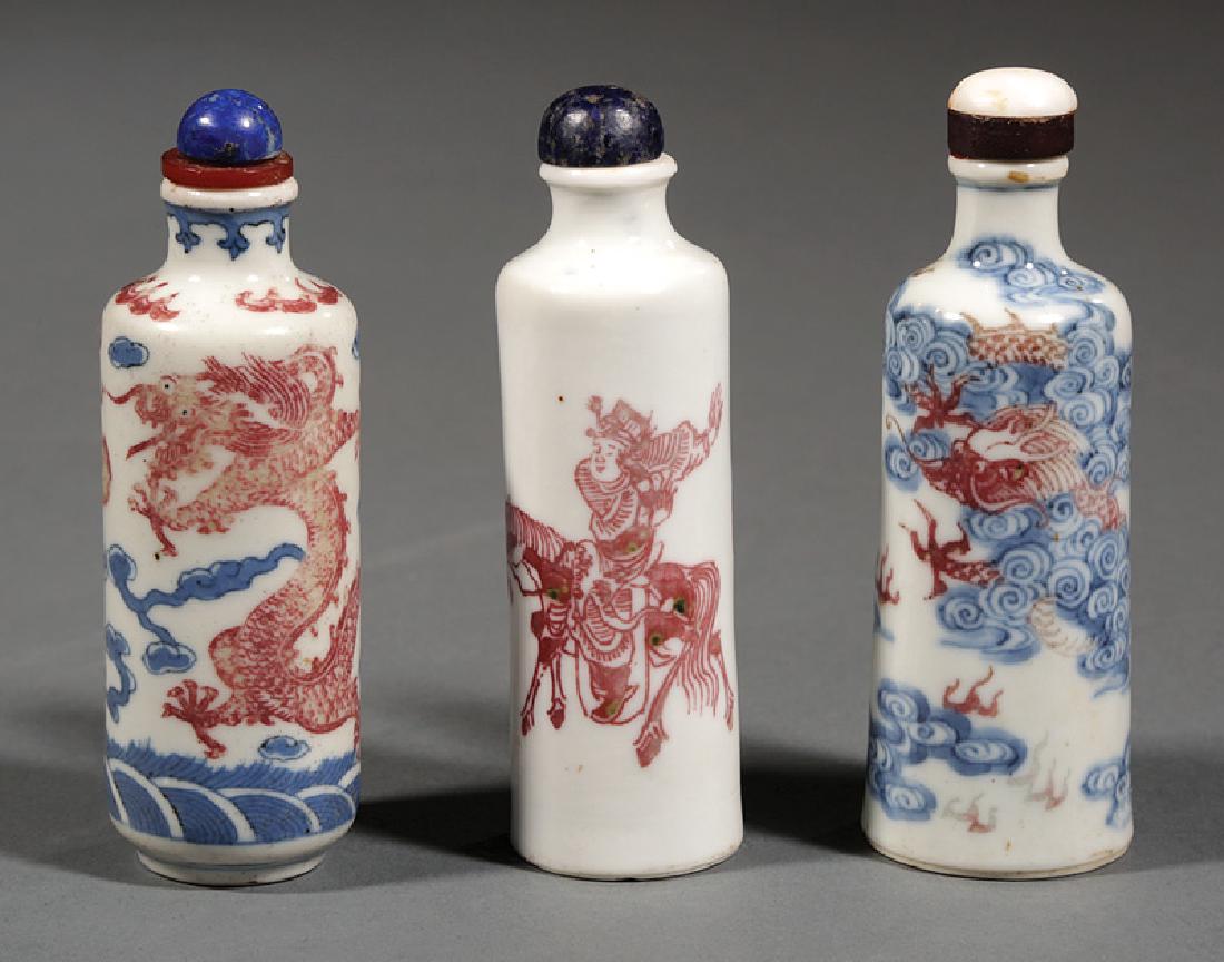Chinese Decorated Porcelain Snuff Bottles: Three Chinese Copper Red Decorated Porcelain Snuff Bottles, stoppers, incl. figural, Qianlong mark, first h. 3 1/2 in.; blue and white with dragon and wave, Yongzheng mark, h. 3 1/2 in.; and blue and 