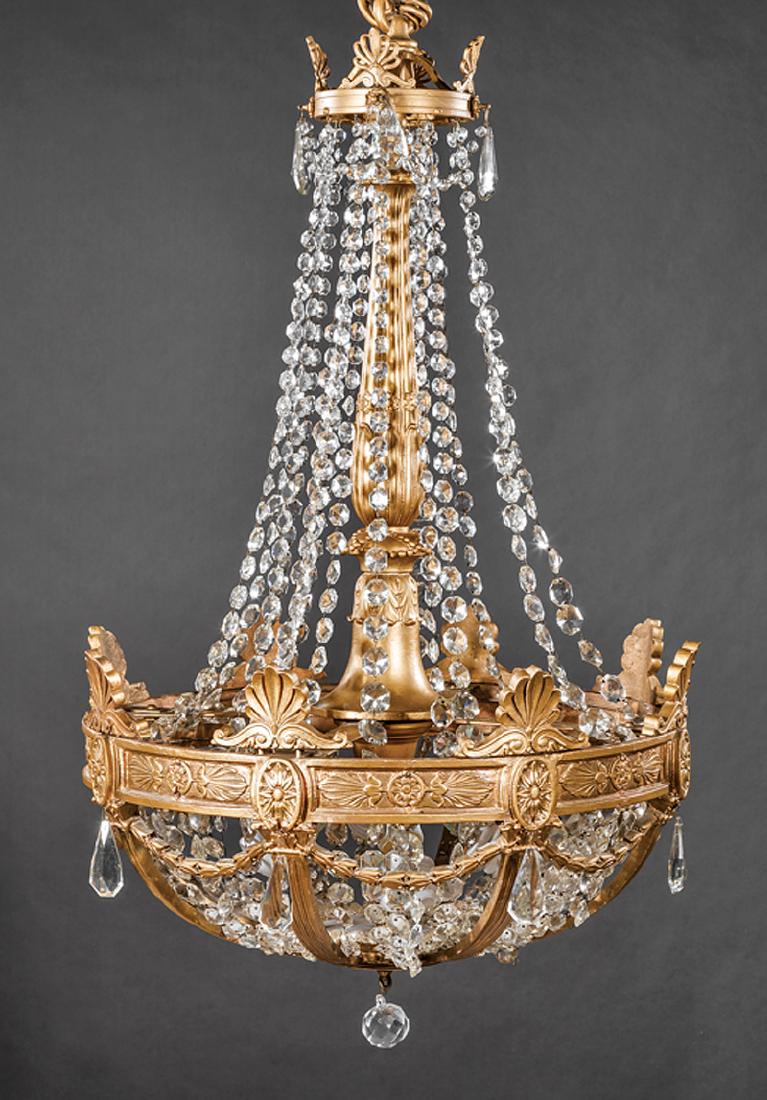 Empire-Style Giltwood and Cut Glass Chandeliers: Pair of Empire-Style Giltwood and Cut Glass Chandeliers, c. 1930, acanthine standard, palmette and bellflower decoration, fitted with four-light fixture, h. 39 in., dia. 25 in., chain l. 36 in