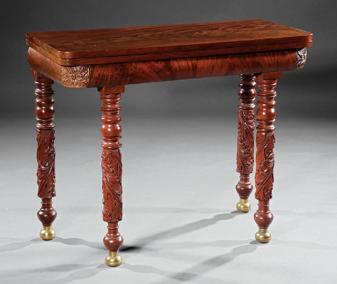 American Classical Carved Mahogany Games Table: American Classical Carved Mahogany Games Table, 19th c., foldover swivel top, interior compartment, bolection frieze with blocked rosette corners, acanthus carved legs, brass ball feet, h. 29 in., l. 