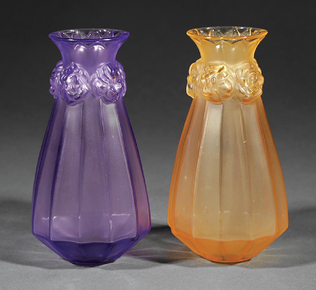 Two Lalique Molded and Frosted Glass Vases: Two Lalique Molded and Frosted Glass Vases, one amethyst, other amber, faceted bodies, necks banded with roses, bases etched "Lalique France", h. 6 1/2 in. Provenance: Estate of Thomas Greene Collins,