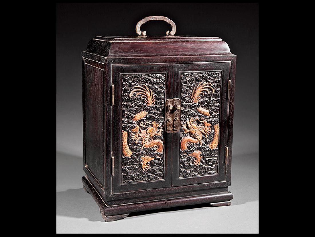 Chinese Mixed Hardwoods Table Cabinet: Chinese Mixed Hardwoods Table Cabinet, loop handle, two doors carved with dragons amid clouds, interior fitted with drawer, bracket feet, reverse with apocryphal Qianlong mark, h. (excluding handle) 1