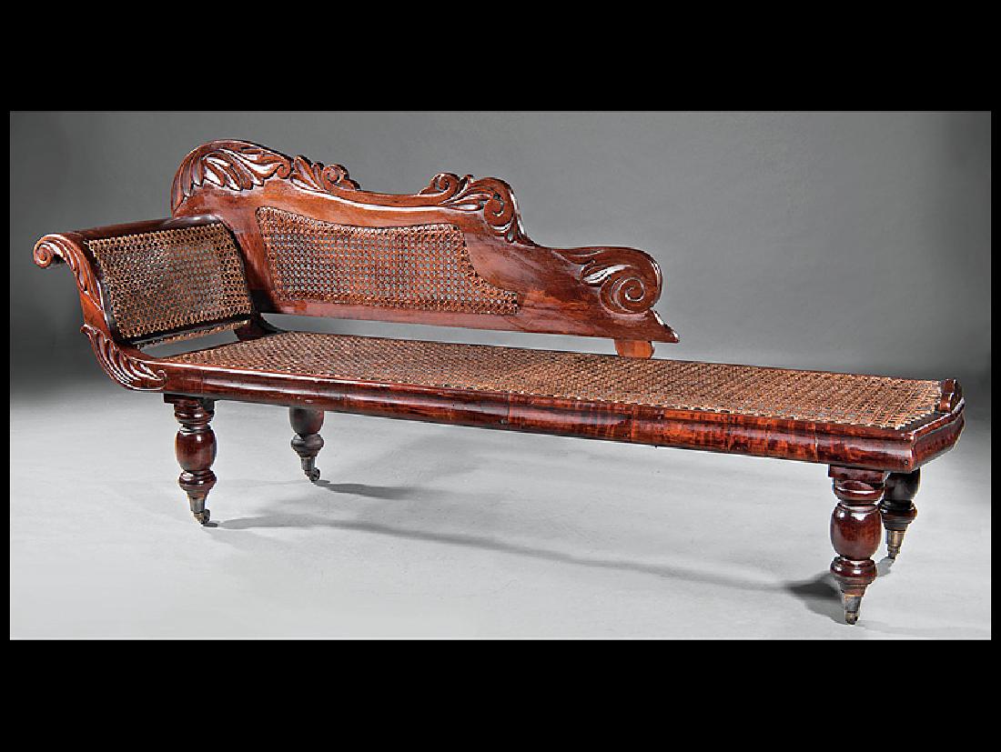 West Indies Carved Mahogany and Caned Meridienne: West Indies Carved Mahogany and Caned Meridienne, 19th c., Trinidad, attr. to French artisans, foliate-carved scrolled crest, conforming arm, molded seat rail, turned legs, casters, h. 35 in., l. 83 i