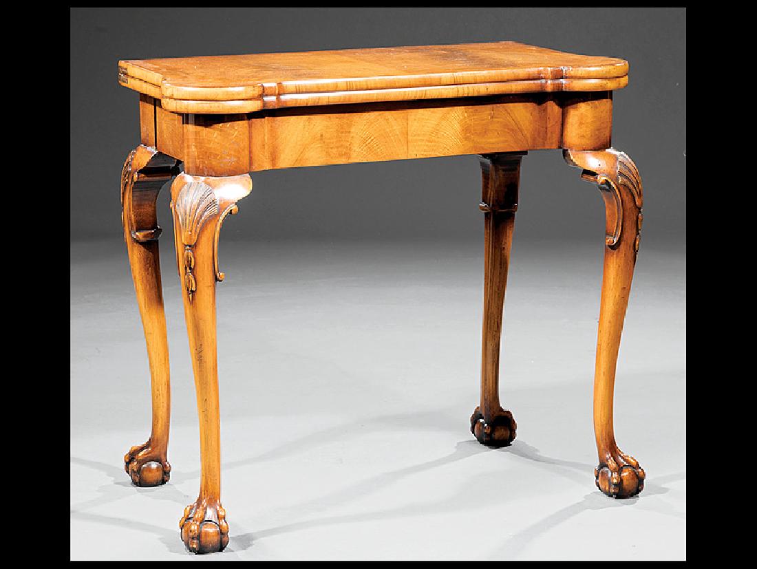 Carved Mahogany Concertina Action Games Table: Irish Queen Anne-Style Carved Mahogany Concertina Action Games Table, shaped foldover top with inset leather playing surface, shell-carved cabriole legs, ball and claw feet, h. 28 1/4 in., w. 33 in., 