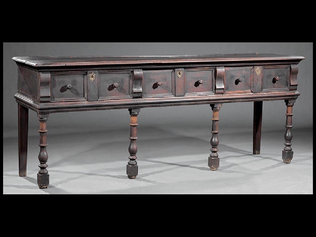 Continental Carved Walnut Side Table: Continental Carved Walnut Side Table, late 18th c., molded top, three frieze drawers, turned legs, blocked feet, old dark surface, h. 33 1/4 in., w. 84 1/2 in., d. 21 in