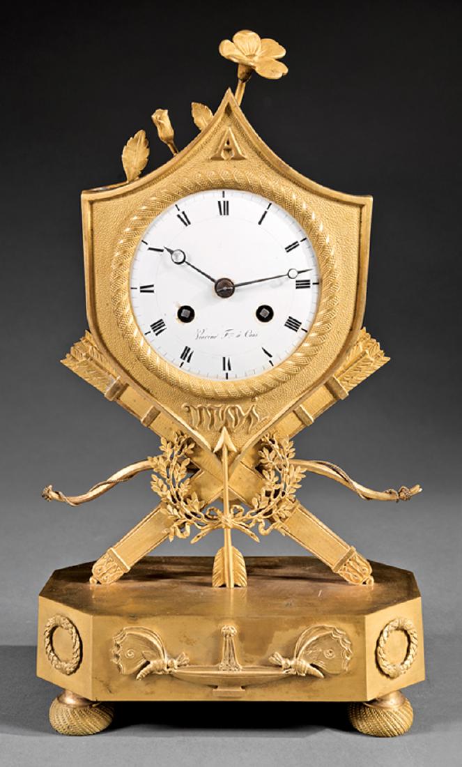 Charles X Gilt Bronze Clock: Charles X Gilt Bronze Clock, c. 1830, shield-form surround cast with "A MOI", supported on quivers, bow, arrow and laurel wreath, silk thread movement, dial marked "Viarino Fres. a Coni", h. 13 in., w
