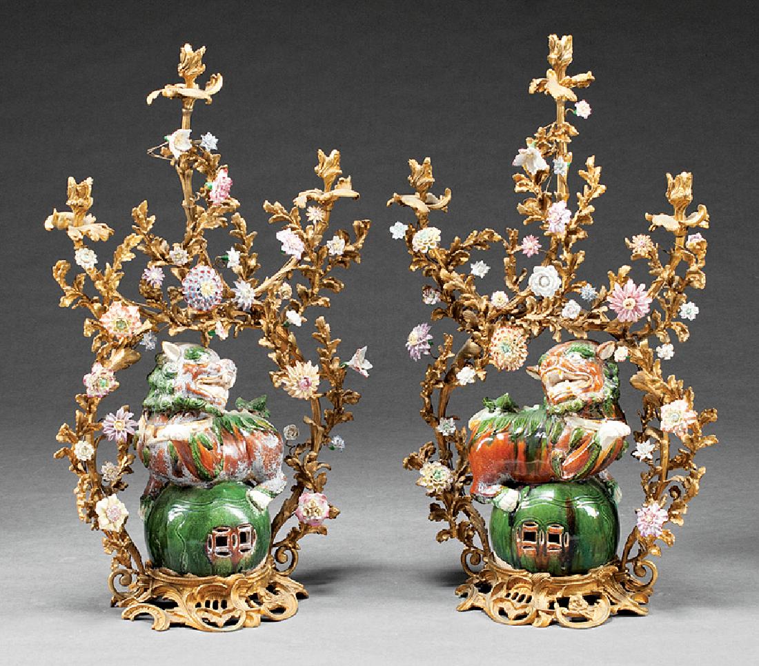 Large Pair of Louis XV-Style Three-Light Candelabra: Large Pair of Louis XV-Style Pottery and Porcelain-Mounted Gilt Bronze Three-Light Candelabra, flower encrusted Rococo foliate frames set with opposing Buddhist lions on brocade balls, h. 33 in., w. 2