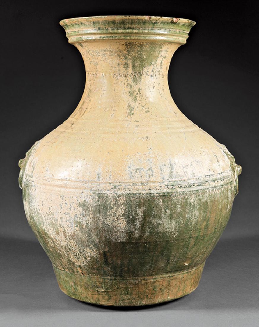 Chinese Lustrous Green Glazed Pottery Hu Vase: Chinese Lustrous Green Glazed Pottery Hu Vase, probably Han Dynasty (206 BCE - 220 CE), baluster body with relief molded and carved concentric bands, shoulders with taotie masks suspending mock rings,