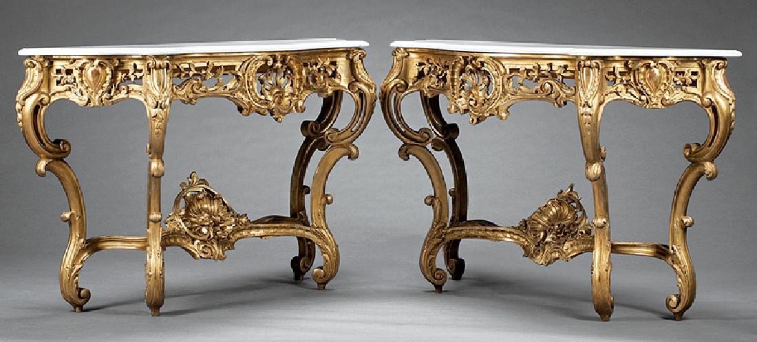 Rococo-Style Carved Giltwood Console Tables: Pair of Italian Rococo-Style Carved Giltwood Console Tables, 19th c., serpentine marble top, pierced foliate apron, scrolled legs, stretcher surmounted by rocaille decoration, h. 36 in., w. 60 in., d.