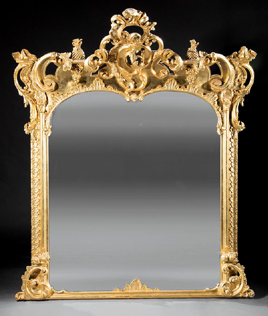 Rococo Revival Carved Giltwood Overmantel Mirror: Monumental Rococo Revival Carved Giltwood Overmantel Mirror, mid-19th c., foliate rocaille cartouche crest, pineapple and grape accents, shaped foliate carved mirror surround, scrolled brackets at bas