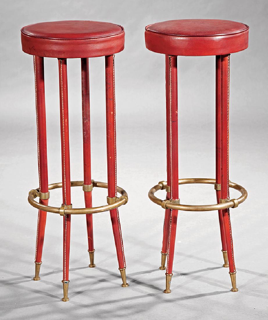 Jacques Adnet Stitched Leather and Brass Stools: Pair of Jacques Adnet Stitched Leather and Brass Stools, c. 1955, circular leather seat and foot rest, leather covered legs, capped feet, h. 31 1/2 in., dia. 12 in