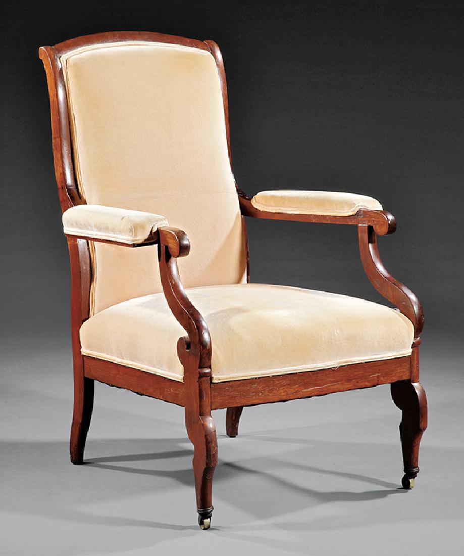 American Classical Carved Rosewood Armchair: American Classical Carved Rosewood "Voltaire" Armchair, mid-19th c., school of Duncan Phyfe, New York, arched crest, padded back, arms and seat, S-scroll supports, saber legs, casters