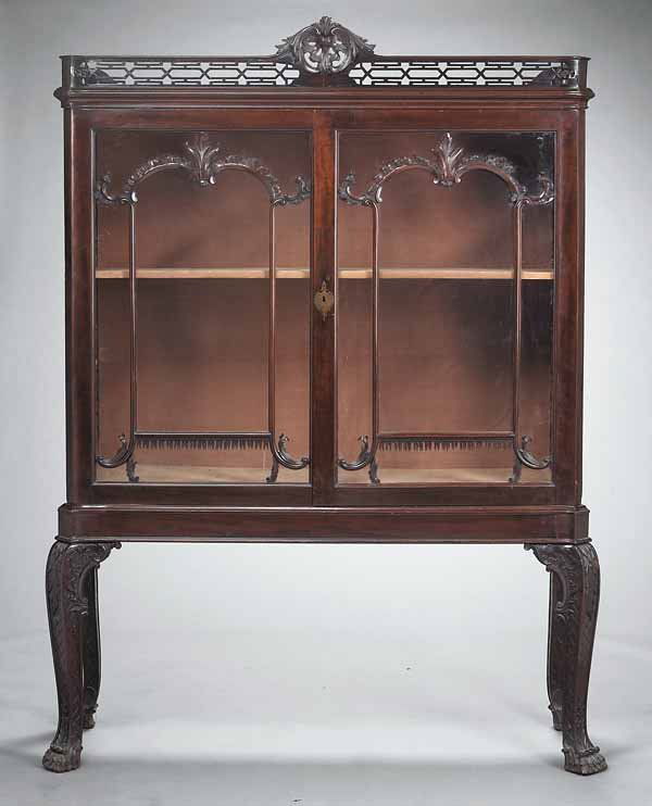 English Mahogany Cabinet, Chippendale style: A Fine Antique English Carved Mahogany Cabinet, in the style of Thomas Chippendale, with a fretwork gallery above glazed doors, on four cabriole legs, height 87 in., width 64 in., depth 22 1/2 in. * N