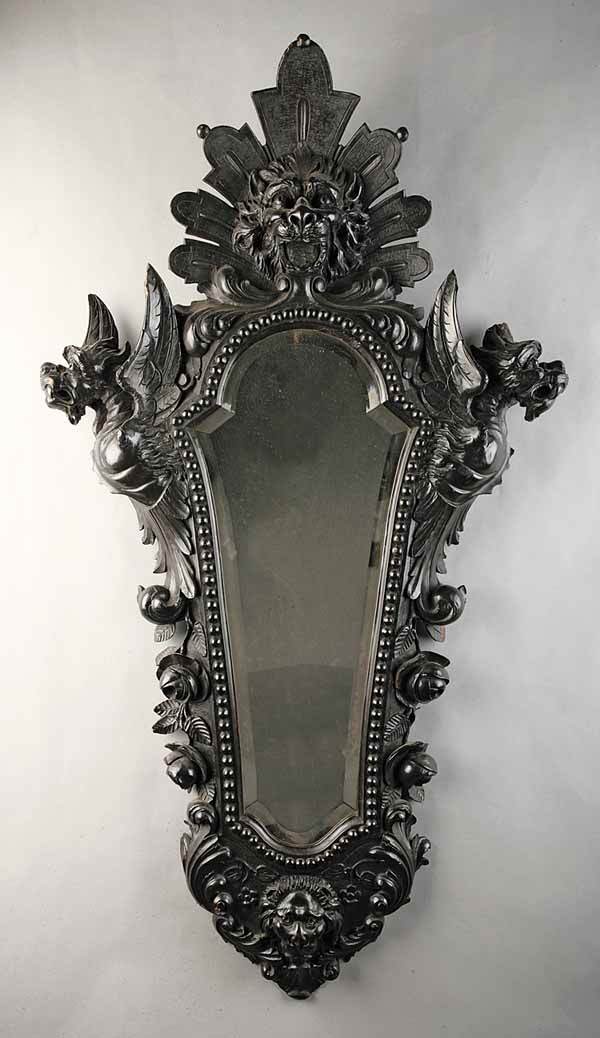 Continental Rococo Carved Walnut Mirror: An Antique Continental Rococo Carved Walnut Mirror , 19th c., the shield-shaped frame with beaded molding surrounding the beveled mirror adorned with griffins, acanthus and roses cresting in a pierced