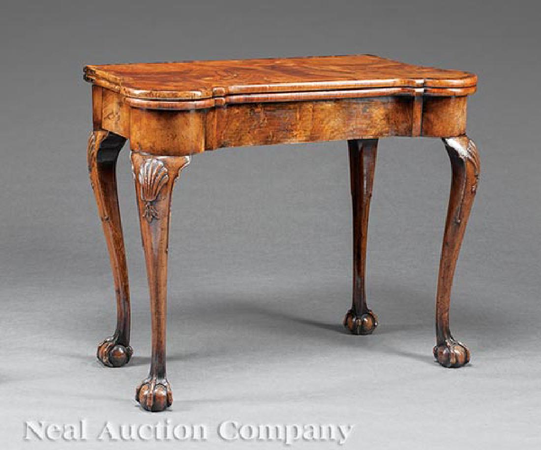 Walnut Concertina Action Games Table: George III Carved and Figured Walnut Concertina Action Games Table, probably late 18th c., shaped foldover top with tooled leather playing surface, conforming frieze, shell-carved cabriole legs, ball 