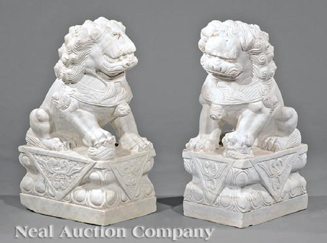 Pair of Chinese Marble Buddhist Lions: Pair of Chinese Marble Buddhist Lions, carved squatting on rectangular plinths with one paw resting on a pup or brocade ball, h. 26 in., w. 10 1/2 in. d. 14 1/8 in. and d. 15 1/8 in.