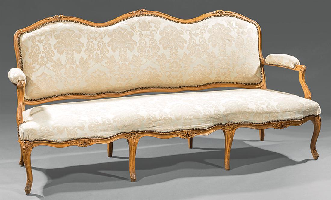 Louis XV-Style Carved Fruitwood Canape: Antique Louis XV-Style Carved Fruitwood Canape, serpentine floral carved crest rail, padded scrolled arms, conforming seat rail, cabriole legs, h. 37 in., w. 77 in., d. 30 in. Note: Condition. Provena