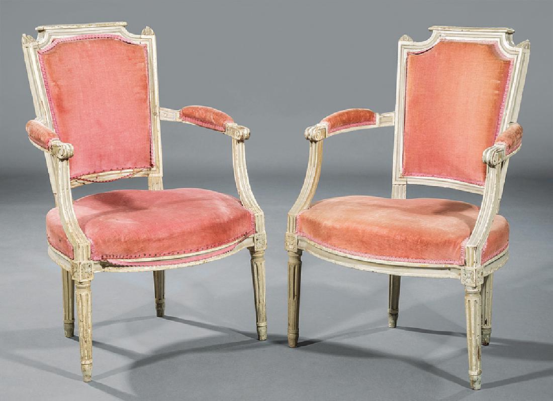 Pair of Louis XVI Carved Creme Peinte Fauteuils: Pair of Louis XVI Carved Creme Peinte Fauteuils, late 18th/early 19th c., shaped crest rail, foliate finials, padded back and arms, rosette blocked seat rail, fluted tapered legs, h. 34 1/2 in., w. 22