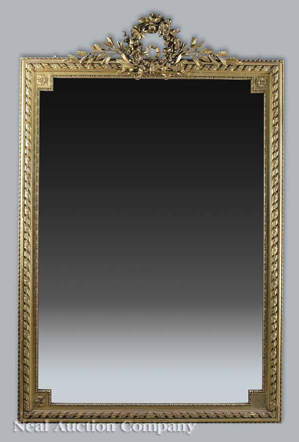 Antique Louis XVI-Style Giltwood Mirror: An Antique Louis XVI-Style Giltwood Mirror , the crest with a beribboned floral wreath, laurel branches to the sides, rosette beaded inner frame with molded continuous ribbon and leaf outer frame with