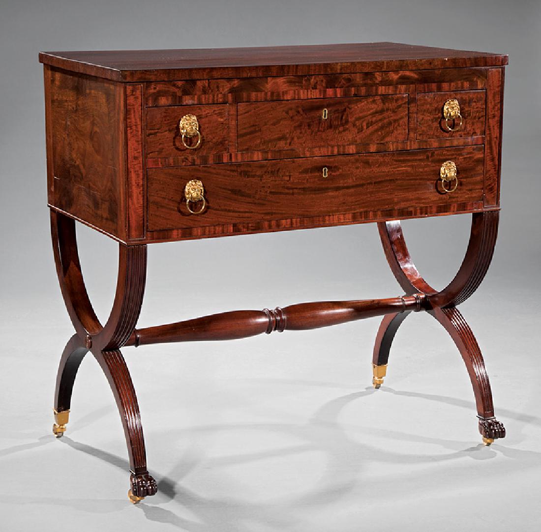 American Classical Carved Mahogany Chamber Table: American Classical Carved Mahogany Chamber Table, c. 1820, attr. to Duncan Phyfe, New York, case with three drawers, reeded curule base, turned stretcher, paw feet, casters, h. 35 1/4 in., w. 36 in.,