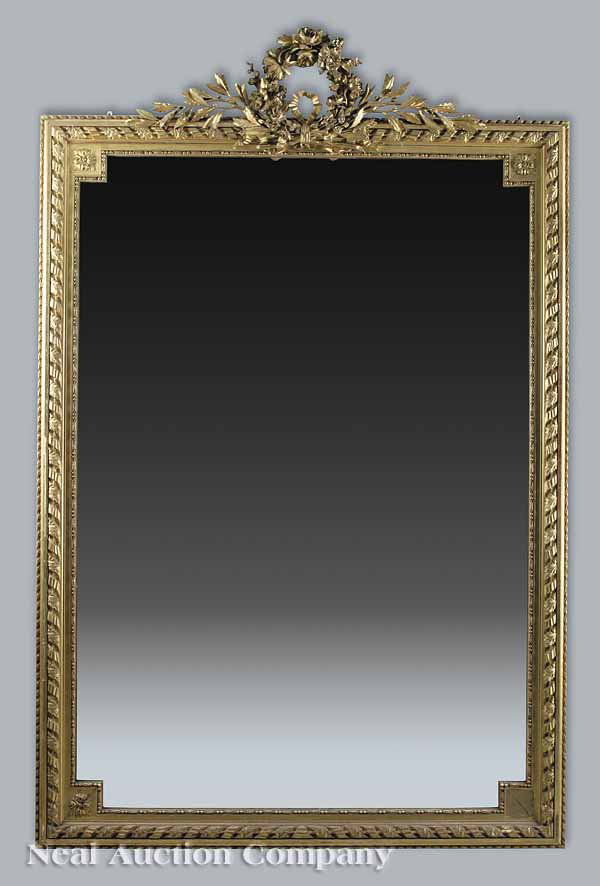 Antique Louis XVI-Style Giltwood Mirror: An Antique Louis XVI-Style Giltwood Mirror , the crest with a beribboned floral wreath, laurel branches to the sides, rosette beaded inner frame with molded continuous ribbon and leaf outer frame with