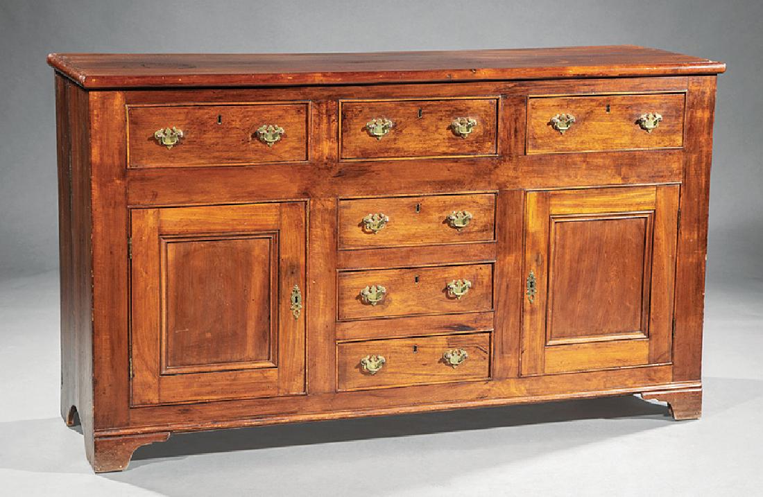Georgian Mahogany Dresser Base: Georgian Mahogany Dresser Base, c. 1820-1830, three frieze drawers over a bank of short drawers flanked by paneled cupboard doors, batwing brasses, bracket feet, h. 35 1/2 in., w. 61 5/8 in., d. 18 7/