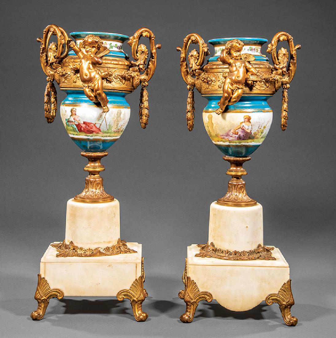 Beaux Arts Bronze-Mounted Sevres-Style Urns: Pair of Beaux Arts Bronze-Mounted Sevres-Style Urns, scroll and wreath handles, centered by a cherub, tall marble base, h. 19 3/4 in., w. 8 1/2 in., d. 5 3/4 in