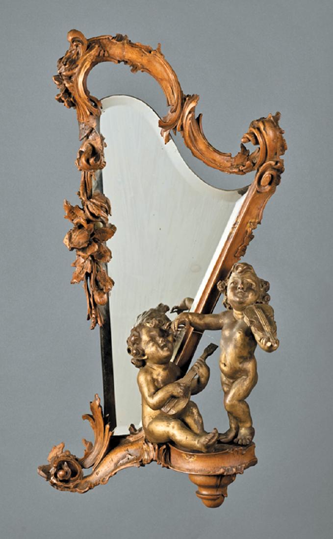 Italian Carved and Gilt Walnut Figural Mirror: Italian Carved and Gilt Walnut Figural Mirror, late 19th c., shaped beveled plate in a foliate-carved harp frame, two putti at base, one playing the violin, h.29 in., w. 16 in., d. 7 in