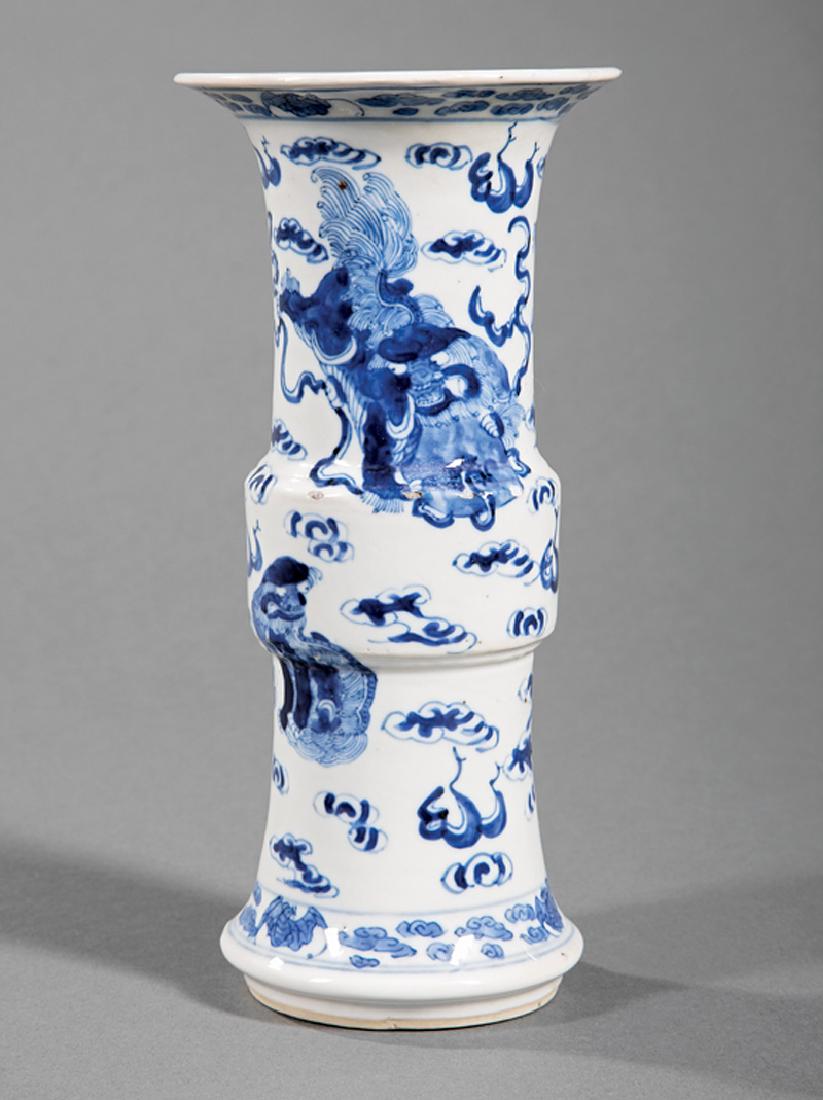 Chinese Blue and White Porcelain Gu Vase: Chinese Blue and White Porcelain Gu Vase, 19th/20th c., decorated with Buddhist lions amid cloud scrolls between bat and cloud bands, base with Kangxi mark, h. 8 in. Provenance: Property of the Mobile