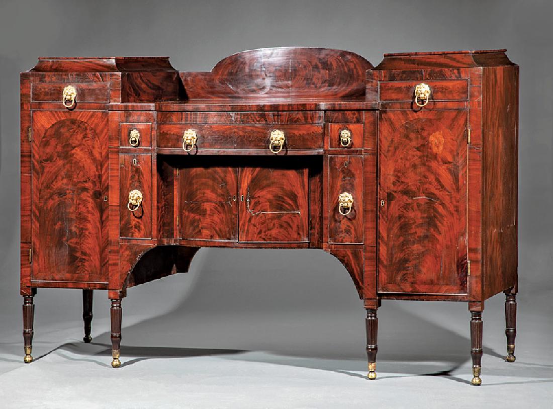American Late Federal Carved Mahogany Sideboard: American Late Federal Carved Mahogany Sideboard, early 19th c., possibly Duncan Phyfe, New York, arched backsplash, bowfront top flanked by raised plinths with drawers, figured paneled doors below, fl