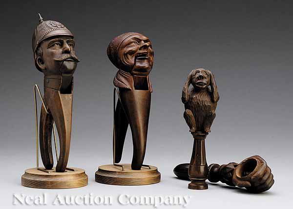 Group of Four Carved Walnut Figural Nut Crackers: A Group of Four Carved Walnut Figural Nut Crackers , early 20th c., probably German, two of the scissor-type with well-carved soldier or old woman heads, and two screw-type implements, one hand-shaped