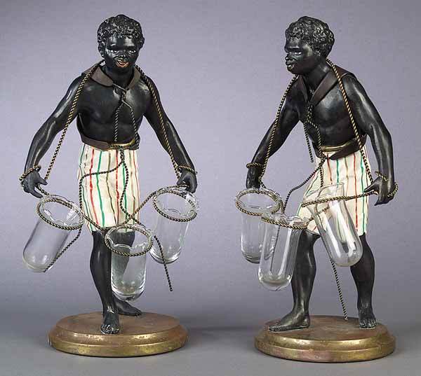 A Pair of Vintage Painted Metal Blacka: A Pair of Vintage Painted Metal Blackamoor Figural Epergnes , the patinated figures with rope harness encircling three glass vessels, on molded brass base, height 13 1/2 in., width 8 in., depth 5 1/2