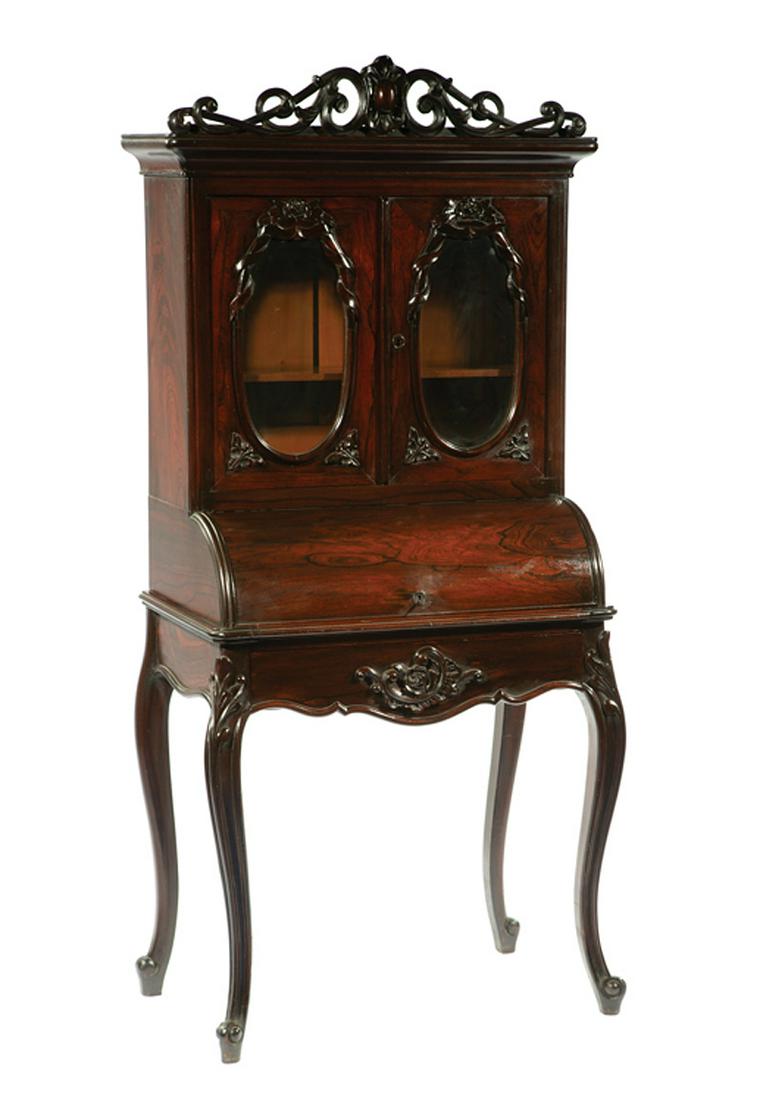Rosewood and Grained Diminutive Cylinder Desk: American Rococo Rosewood and Grained Diminutive Cylinder Desk , 19th c., ogee cornice, rosette-carved oval glazed doors, retracting cylinder lid, serpentine frieze drawer, cabriole legs, h. 63 in., w.