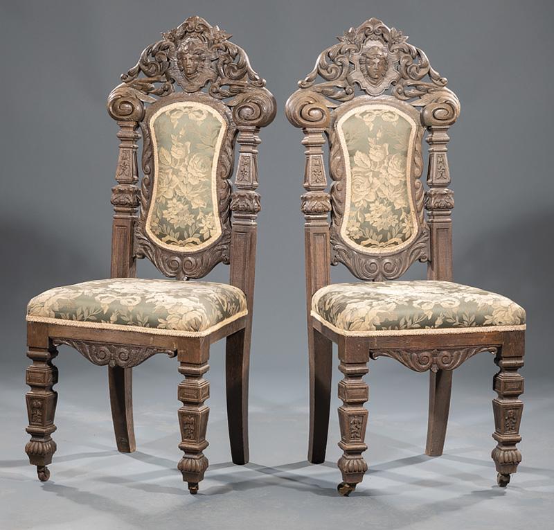 Renaissance Revival Carved Oak Side Chairs: Pair of Renaissance Revival Carved Oak Side Chairs , late 19th c., arched foliate-carved crests centered by masks, scrolled ears, faceted and blocked foliate stiles, scroll-carved seat rail, conformin