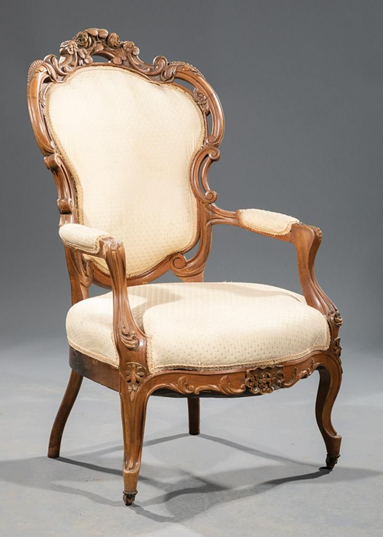 American Rococo Carved Walnut Armchair: American Rococo Carved Walnut Armchair , mid-to-late 19th c., C scroll foliate pierced crest rail, padded arms, cabriole legs, casters, h. 41 in., w. 24 1/2 in., d. 24 in. Condition: Structurally soun