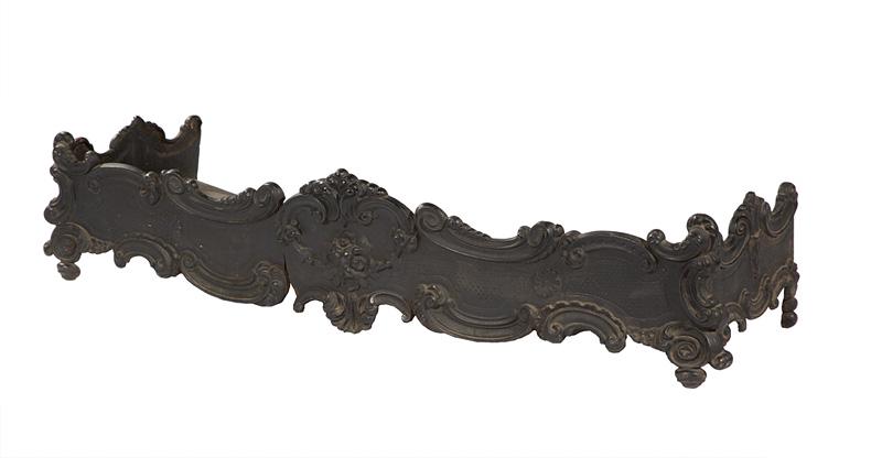 Rococo-Style Cast Iron Fire Fender: Rococo-Style Cast Iron Fire Fender , C-scroll, floral and shell motif, h. 8 in., w. 40 3/4 in., d. 12 in. Condition: broken; split in front through entire piece . Provenance: 511 St. Ann Collection, H