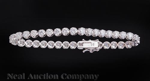 18 kt. White Gold and Diamond Bracelet: 18 kt. White Gold and Diamond Bracelet , comprised of 37 half bezel set diamonds, total wt. approx. 6.77 cts., l. 8 1/4 in **Please note: Payment for all jewelry purchases must be made by cash, check 