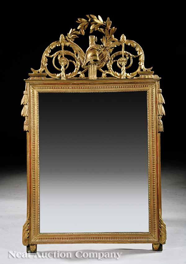 Louis XVI-Style Carved Giltwood Mirror: An Antique Louis XVI-Style Carved Giltwood Mirror, scrolling foliate crest with laurel leaves and plumed helmet, pendant tasseled sides, beaded, dentil-molded framed, height 47 in., width 30 in * NO R